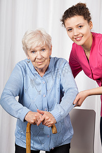 老人拄拐杖走路摄影照片_护士与老年妇女