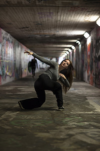 地道摄影照片_在城市地道中表演的女舞蹈家。全长。选择性聚焦. 