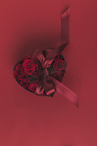 顶部的玫瑰在心形礼品盒与丝带隔离红色, st 情人节假期概念