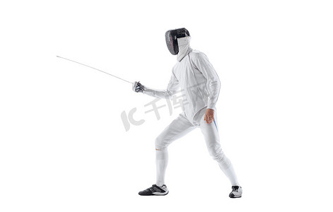 Energy摄影照片_Attack. Dynamic portrait of young man, fencer in in fencing costume with sword in hand training isolated on white background. Athlete practicing in motion, action. Copyspace for ad. Sport, energy