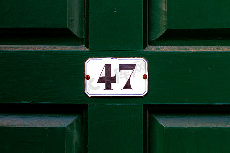 房子的47号，白色的牌匾上有一个深绿色的木门