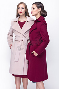 时尚fashion摄影照片_Two Pretty girls in fashionable stylish clothes, on a white background. Beauty, fashion, style.