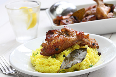 rice摄影照片_chicken and pork adobo over yellow rice, filipino food
