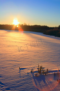 冬季日落。结冰的湖
