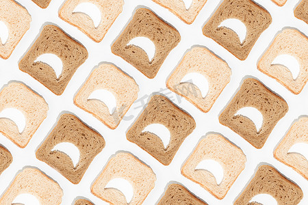 微信emoji图摄影照片_Moody emoji pattern made of slices of white and brown whole grain toast bread on isolated pastel white background. Minimal flat texture. Creative idea of low carb diet. Abstinence from food concept.