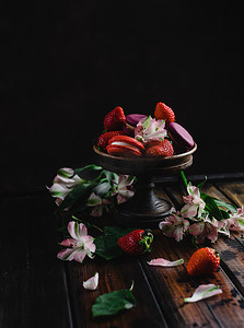 龙与花摄影照片_碗与马卡龙和草莓在木桌与花
