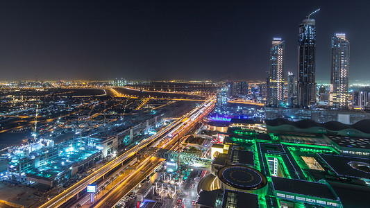 迪拜市中心夜 timelapse 与现代照明摩天大楼, 购物中心和交通的道路上。上方视图