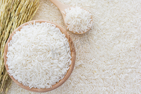 白米饭的碗和一袋，一个木勺和水稻植株上白米饭背景，顶视图 