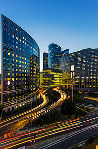 摩天大楼在巴黎商务区拉德芳斯。欧洲夜景观动态街道交通、 汽车灯、 玻璃幕墙的现代建筑。经济、 财政、 交通概念。定了调子