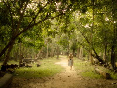 神秘的道路上走进魔法森林里的年轻女子