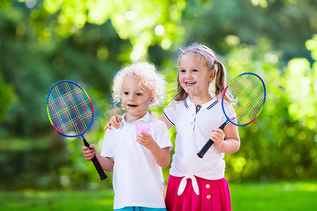 室外篮球场摄影照片_小孩打羽毛球或网球在室外篮球场