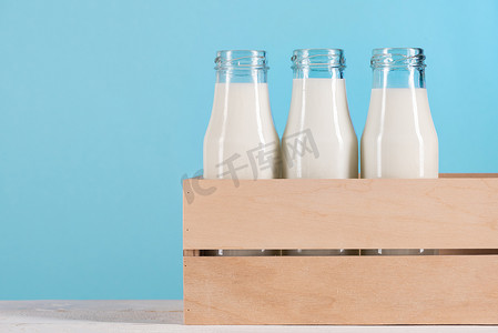 牛奶盒子摄影照片_牛奶在木盒子里的玻璃瓶
