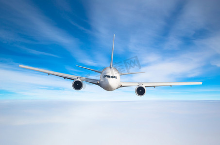 客机飞行水平高在天空上空的云层和蓝色色调的天空。直接在前面查看, 正好.