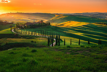 意大利托斯卡纳的绿山和橙色落日的斑斑