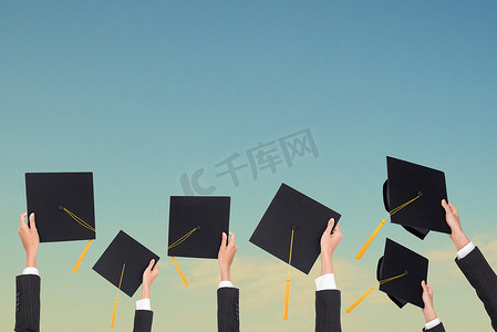 毕业时持有黑色帽子和黄色流苏在蓝天背景.