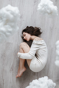 floor摄影照片_Picture of a girl lying on the floor in the clouds