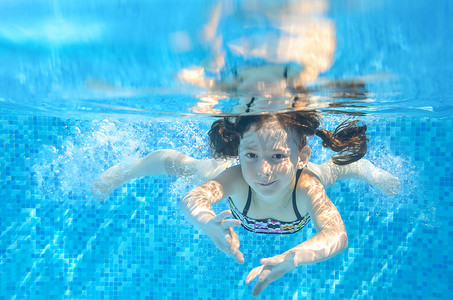快乐积极的水下孩子在游泳池里游泳