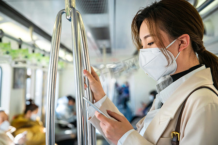 预防新型肺炎病毒摄影照片_青年女人在地铁上看手机