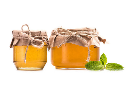 野生椴树蜂蜜摄影照片_新鲜的蜂蜜，放在玻璃罐子里