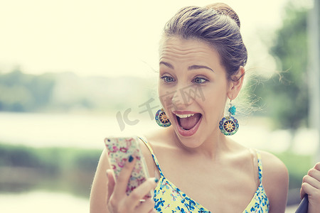 surprised screaming young girl looking at mobile phone