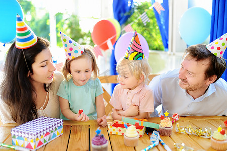 双子生日摄影照片_?儿童和他们的父母有乐趣和庆祝生日聚会