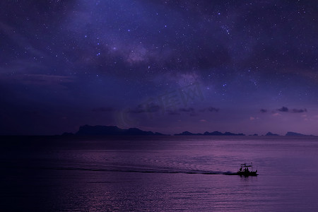 当地渔民在海上的长尾船上, 有百万颗星星的星系天空背景.