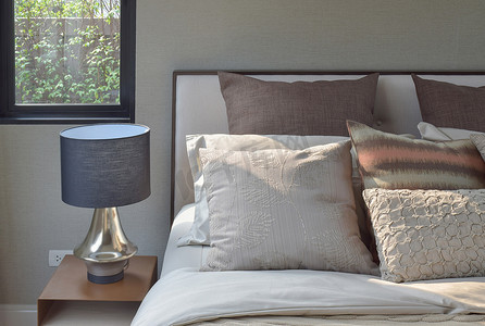 在经典风格床上用品和阅读灯在床边的桌子上设置的优雅风格枕头
