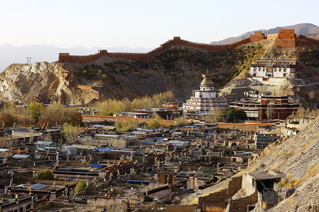 风景如画的西藏高原山地和小旧建筑的前景 