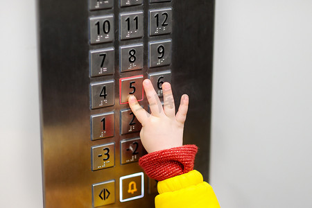 儿童影楼相册摄影照片_在电梯里的小孩按下按钮