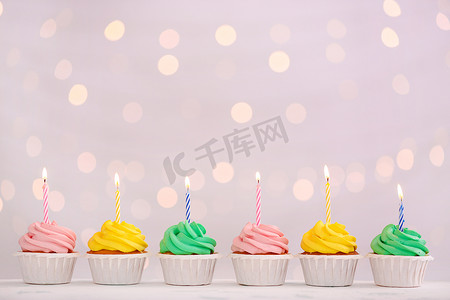 各种灯光摄影照片_各种美味的生日纸杯蛋糕，反对去聚焦的灯光