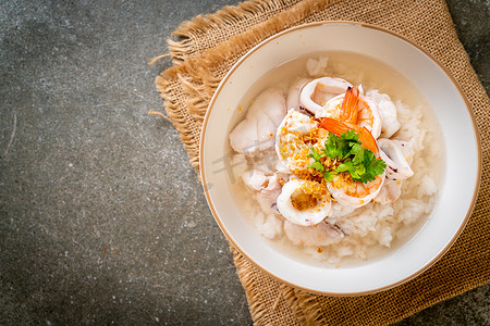 海鲜粥摄影照片_粥或煮米汤配海鲜(虾仁、鱿鱼和鱼)碗