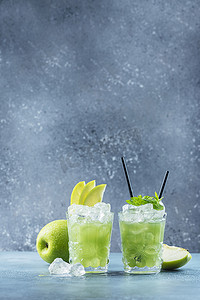 绿色鸡尾酒加冰块和薄荷酒吧概念。苹果莫吉托与薄荷和冰蓝色背景，选择性焦点图像