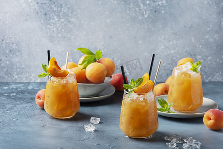 蓝底摄影照片_新鲜的杏仁鸡尾酒，蓝底上有冰和薄荷。选择性聚焦图像。酒吧概念和夏季酒水概念