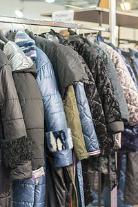 冬季夹克在冬季销售的衣架上。女装商店衣架上的女式外套。垂直照片