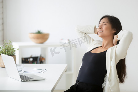 放松愉快的亚洲妇女享受休息在工作场所呼吸 
