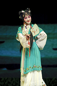 漂亮中国戏曲演员执行与传统服饰的舞台上
