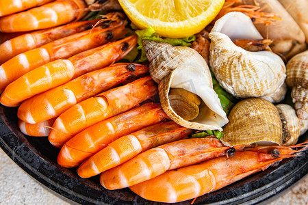 seafood plate assorted shrimps, crab claws, clams, rapan, trumpeter mollusk Takeaway healthy meal food snack on the table copy space food background rustic top view