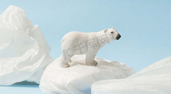 蓝底塑料袋上的白北极熊、塑料污染和气候变化概念