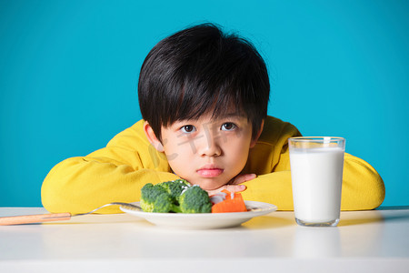 蓝色小学摄影照片_不想吃蔬菜的小男孩