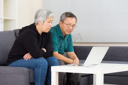 老年夫妇在家使用便携式计算机