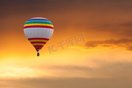 落日天空背景摄影照片_在落日的天空背景上飞行的热气球。节日的彩色气球。户外、 多彩