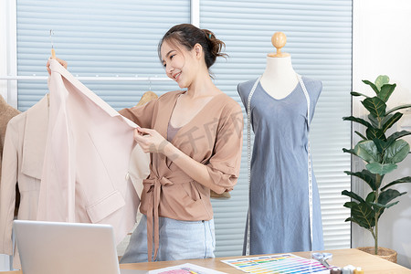 shirt摄影照片_Professional female designers use a tape measure around the shirt mannequins in the studio, Fashion designer, Creativity and ideas, Mannequin, Shirt sketch, Color scheme, Garment accessories.