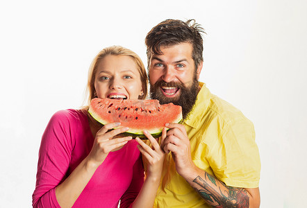 漂亮的夫妇摄影照片_年轻夫妇吃西瓜。一对年轻漂亮的夫妇吃西瓜的画像，笑脸