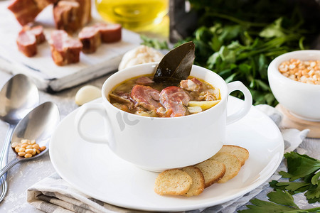传统的自制浓豌豆汤, 在白色盘子里放烟熏肉, 供家庭晚餐使用
