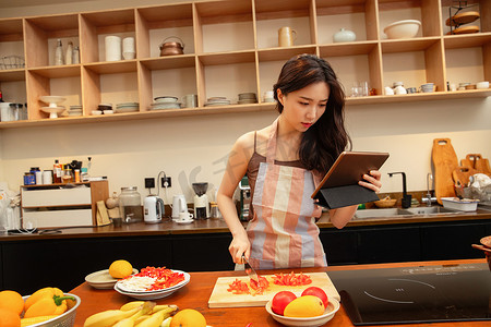 中国菜摄影照片_青年女人在家做饭