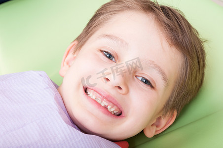 Smiling child with happy face on dentist chair or office