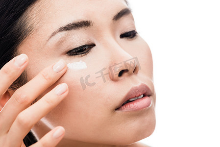 应用 anti-wrinkles 眼霜的年轻女性