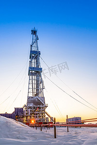 oil摄影照片_Winter polar day in the arctic. Drilling a well at a northern oil and gas field. Low sun. Beautiful lighting.