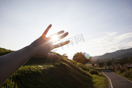 日落和路通过手指, 手剪影在太阳射线        