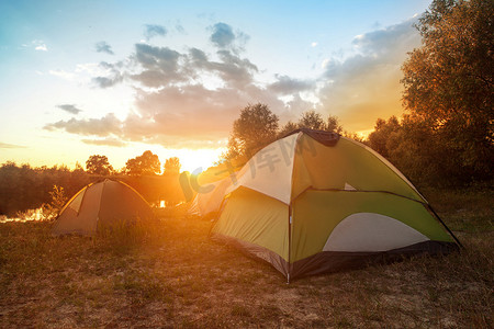 夏日清晨森林河岸上的旅游帐篷 